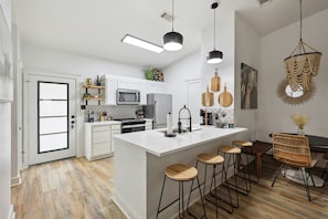 Enjoy cooking and dining in this kitchen with a spacious island, dining area, and large window offering a view.