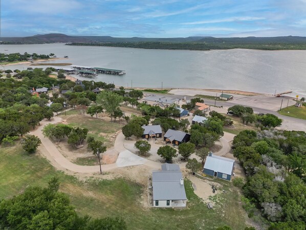 An aerial view of a lakeside community with houses, docks, and boats.