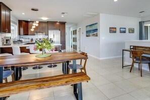 Una cocina moderna con armarios de madera oscura, electrodomésticos de acero inoxidable y una isla central con asientos.