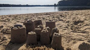 Une plage de sable où l’on peut voir plusieurs châteaux de sable.