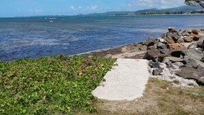 A coastal path with a rocky shoreline, a clear blue sea, and distant mountains. - Villa Picuas MR in Rio Grande Magical place (Río Grande)