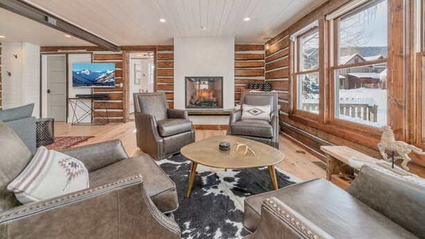 A cozy living room with leather sofas, a round coffee table, and a fireplace.