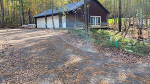 A cabin with a metal roof, a garage, and a wooden deck. - Anna Bananas Beachfront Bungalow (Hazelhurst)