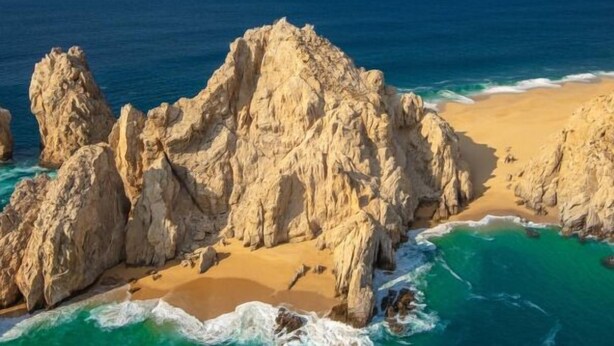 Eine Küstenlandschaft mit Felsformationen und einem Sandstrand.