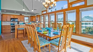 Un'ampia cucina con mobili in legno, un'isola centrale e grandi finestre con vista sul quartiere.