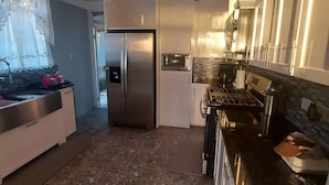 Una cocina moderna con un refrigerador de acero inoxidable, un microondas y una estufa.