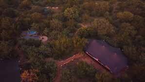 An aerial view of a secluded property with a swimming pool, a covered outdoor area, and a large pond. - Canvas Villa with pool (Hoedspruit)