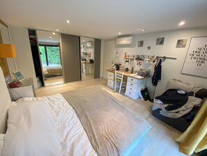 Un dormitorio moderno con una cama grande, un escritorio y un armario.