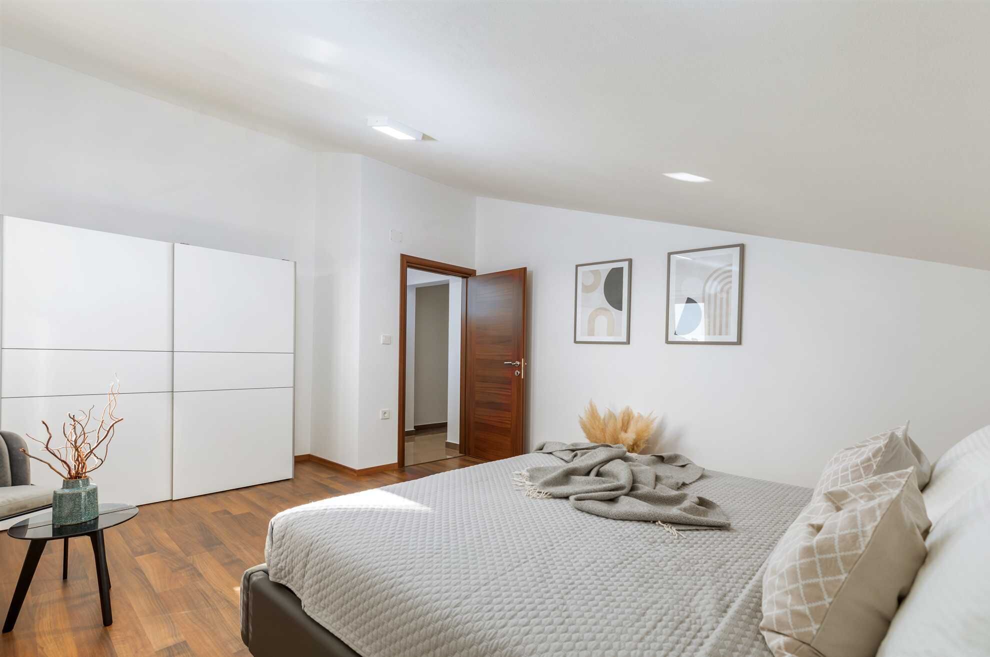 Ein Schlafzimmer mit einem Bett, einem Kleiderschrank und einer Tür zu einem anderen Raum.