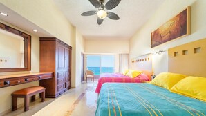 Une chambre d’hôtel avec un lit, un bureau, une chaise et une vue sur la mer.
