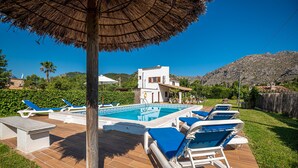 A pool area with lounge chairs and a thatched umbrella. - XIM ( Angels ). Nice villa within walking distanace to Pollensa (Pollensa)