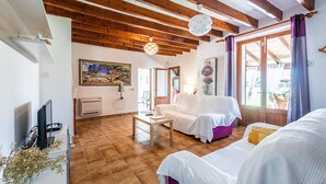 A cozy room with a wooden ceiling, a white sofa, a small table, and a TV. - XIM ( Angels ). Nice villa within walking distanace to Pollensa (Pollensa)