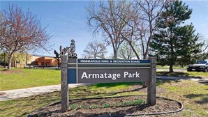 A sign for Armatag Park, part of the Minneapolis Park & Recreation Board, with a clear sky and trees in the background. - Sunny Retreat Haven (Minneapolis)