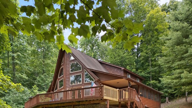 A cabin with a stone facade, wooden deck, and a covered porch. - Large Cabin Located on Deer Water Lake (Rogers)