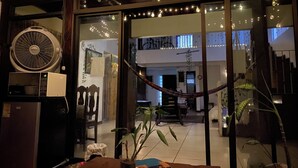 Ein modernes Interieur mit einem großen Ventilator, einer Hängematte und Topfpflanzen.