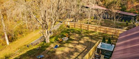 A backyard with a hot tub, fire pit, and outdoor seating area.
