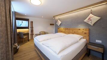 Une chambre d’hôtel moderne avec un grand lit, un bureau et une télévision.