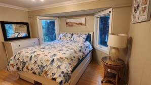A bedroom with a bed, a dresser, a mirror, a window, and a lamp. - LaVerna! LaVerna! (Ocean Park)