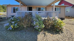 A single-story motel with a covered porch and a small garden area in front.