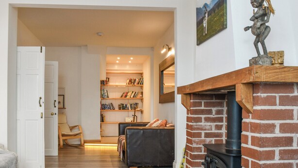 A cozy living room with a fireplace, a bookshelf, and a comfortable seating area. - A spacious town house, with lots of character. (Newquay)
