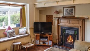 A cozy living room with a fireplace, a television, and a comfortable sofa. - 2 bedroom accommodation in Sawrey, near Ambleside (Sawrey, near Ambleside)
