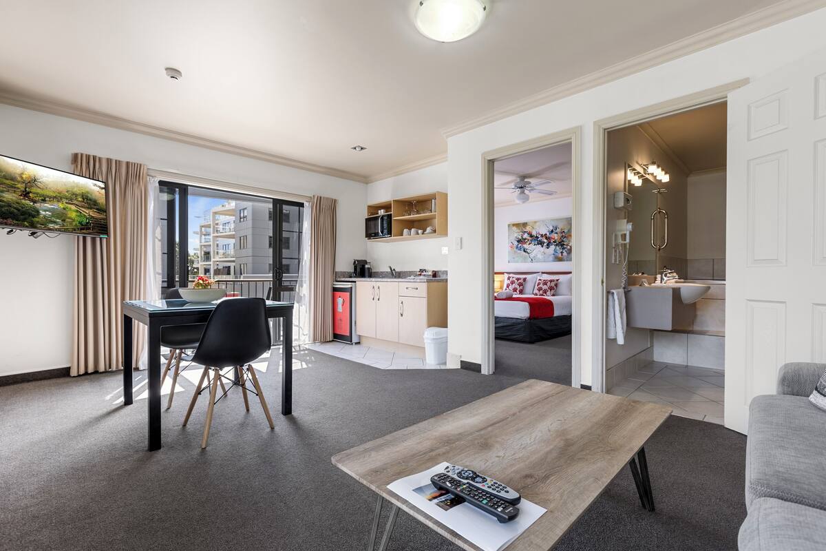 A modern apartment with a dining area, kitchen, and living space.