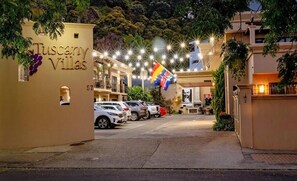 A hotel entrance with a sign reading "Tuscany Villas" and a flag. - Tuscany Villas Boutique Motel  (Whakatane)