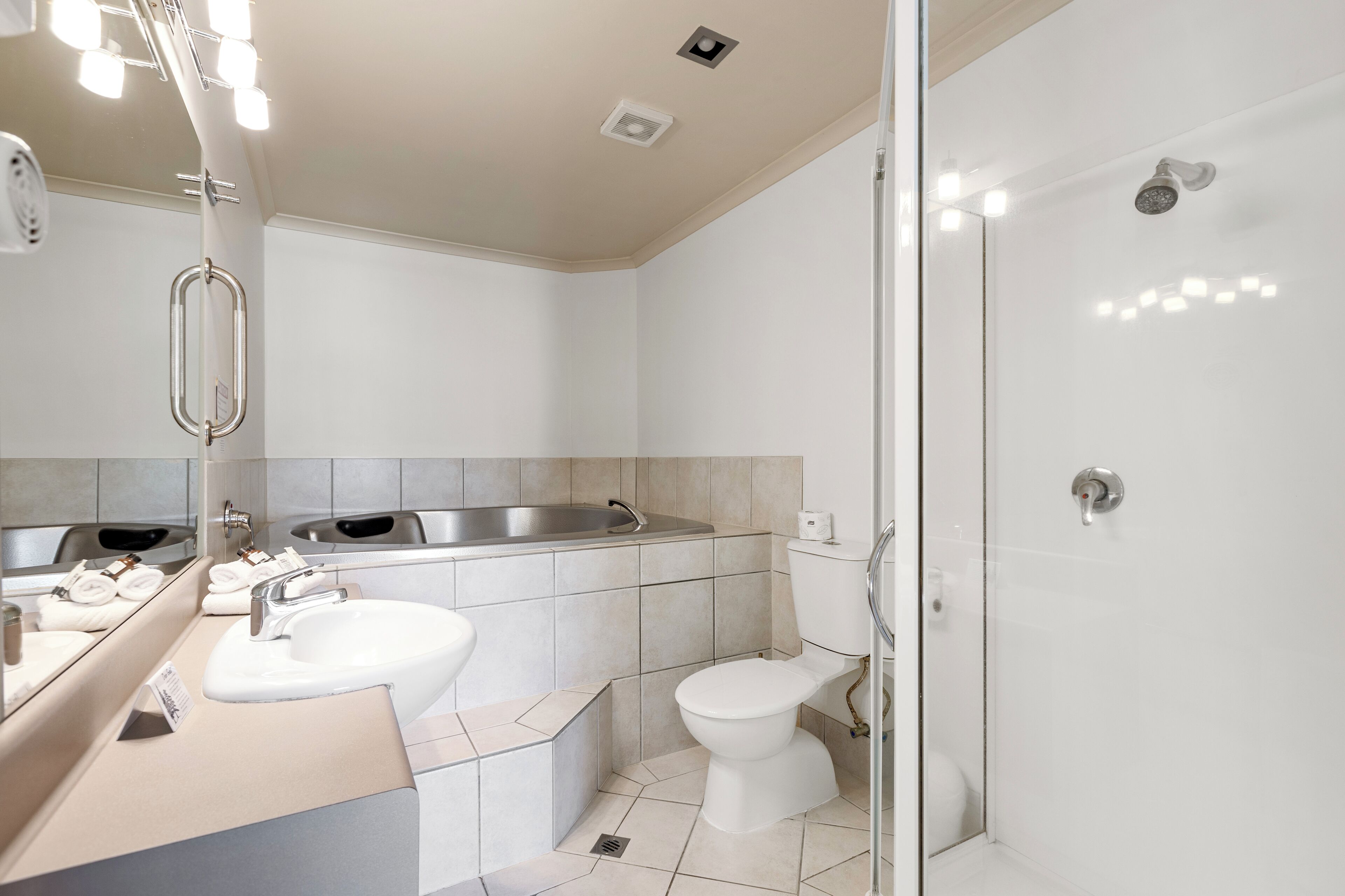 Une salle de bain moderne avec un lavabo, des toilettes et une douche à parois de verre.
