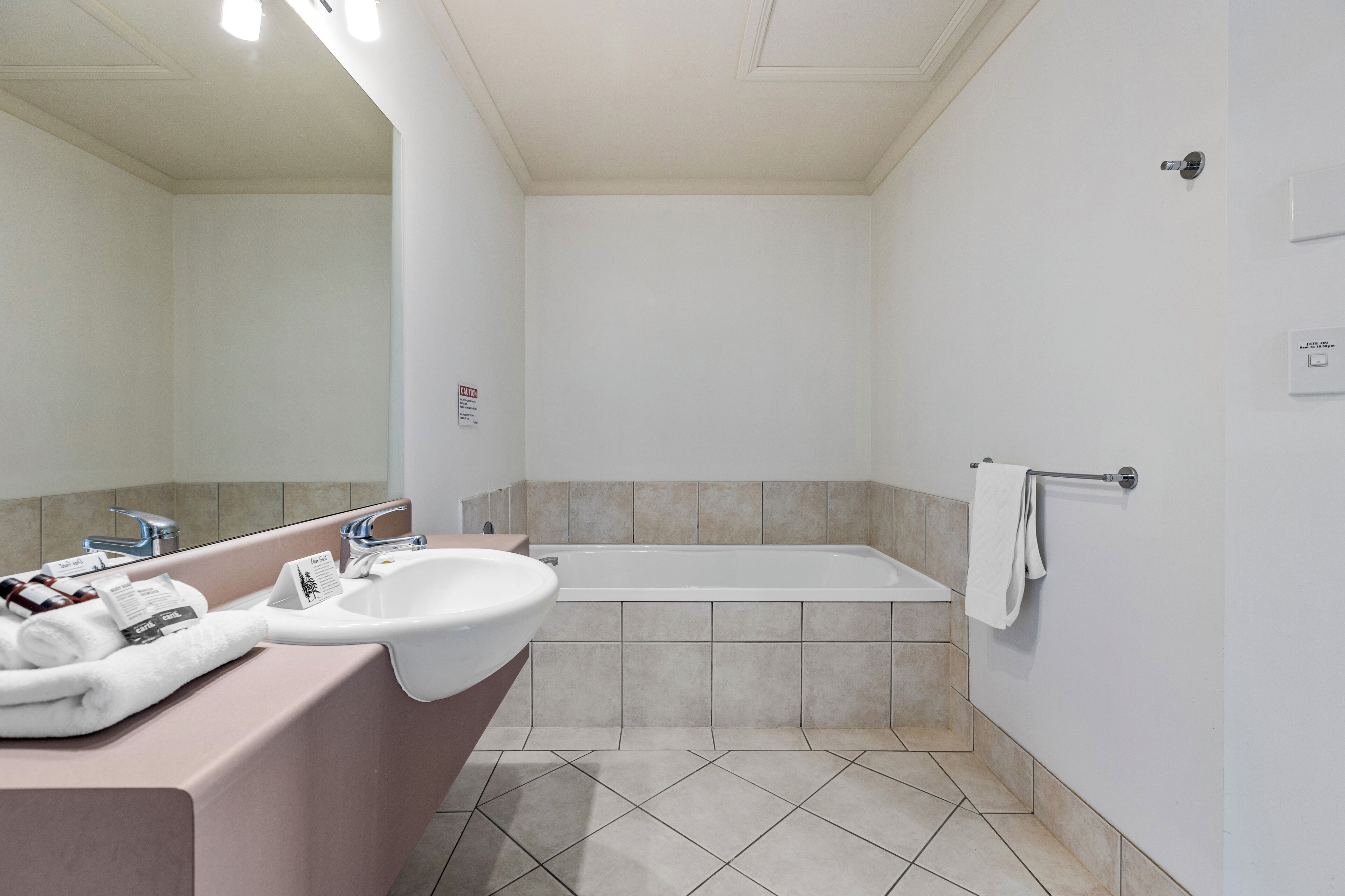 Un bagno moderno con lavandino, specchio e vasca.