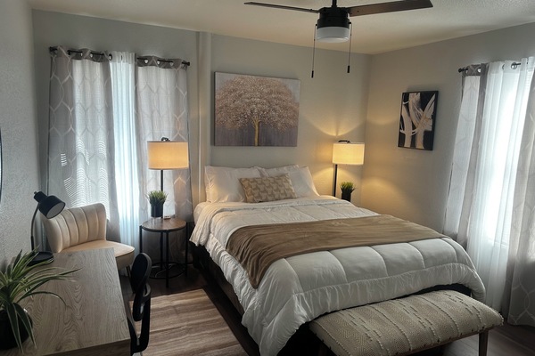 first bedroom with queen bed extra pillows and blanket