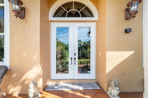 A double door with a glass panel, a welcome mat, and two statues on either side. - Near Lion Country Safari! Large Family-sized home (Loxahatchee)