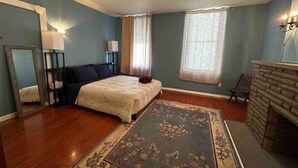 A bedroom with a bed, a nightstand, a mirror, a dresser, and a fireplace. - Charming, cheerful, comfortable, centrally located, and walkable!


 (Pittsburgh)
