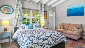 A bedroom with a bed, a sofa, a window with curtains, a painting, and a lamp. - Perfect Urban Escape: Your Personal Oasis with a Zen Den and Lush Gardens! (Delray Beach)