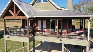 Een twee verdiepingen tellend huis met een overdekte veranda en een schoorsteen.
