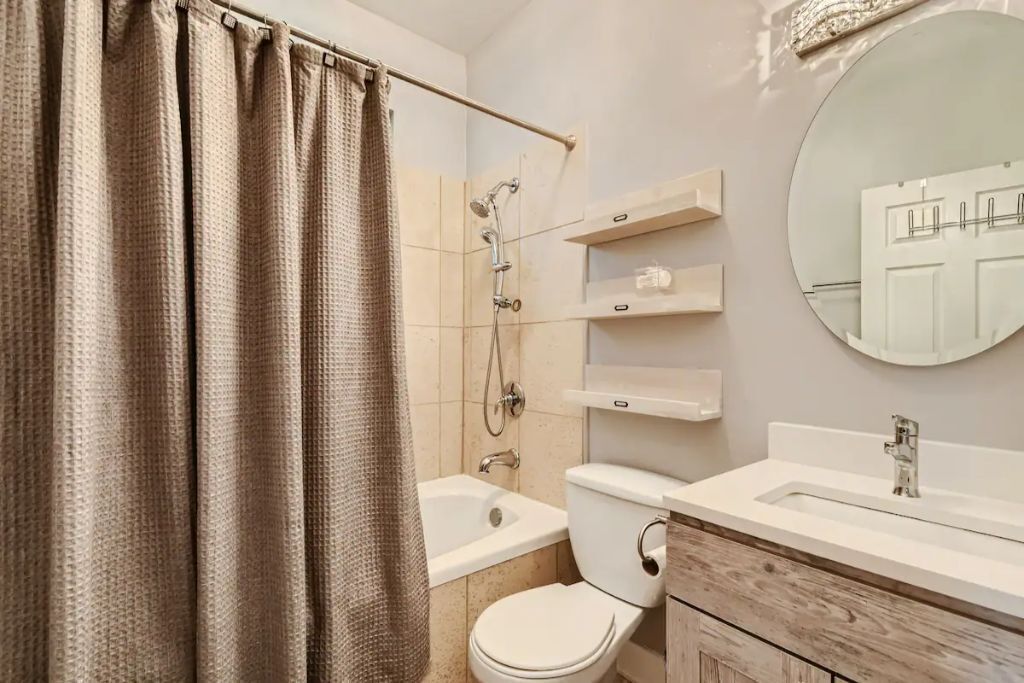 Ein modernes Badezimmer mit Dusche, Toilette, Waschbecken und Spiegel.