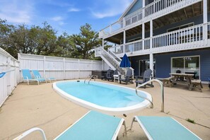 Une piscine avec des chaises longues et un espace aménagé autour.