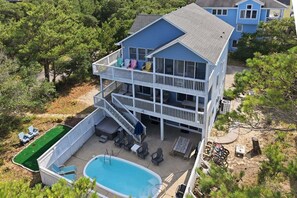 Un bâtiment à deux étages doté d’une piscine, d’un espace extérieur aménagé et d’une terrasse couverte.