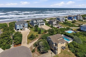 A coastal residential area with houses, a swimming pool, and a beach view.