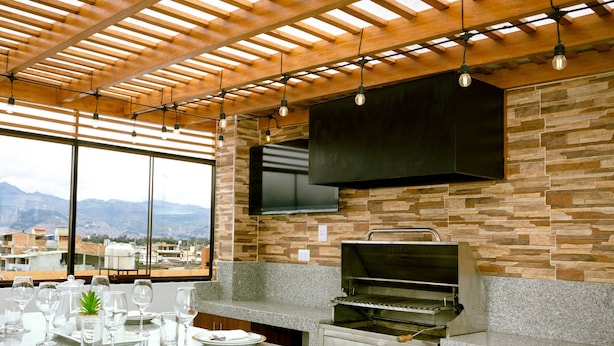Una cocina moderna con salpicadero de piedra, horno empotrado y un amplio ventanal con vistas a la ciudad.