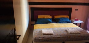 A hotel room with a bed, a nightstand, and a small table. - Un Joli Appartement Premium 23 (Marrakech)