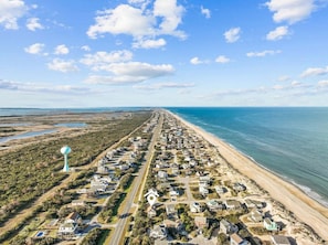 Une zone résidentielle côtière comprenant des maisons, une route et une plage.