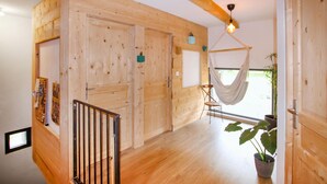 A wooden interior with a hammock, a potted plant, and a door with a small window. - Stunning home in Darbres (Darbres)