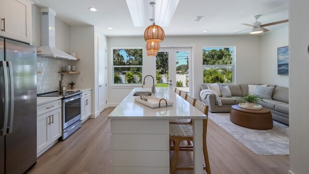 A modern kitchen with white cabinetry, stainless steel appliances, and a large island. - 3BR Lux Home, Heated Pool, Fire Pit, Outdoor TV (Palmetto)