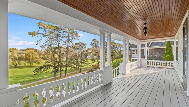 A covered porch with a view of a golf course. - Kennebunk's Golf and Beach Haven (Kennebunk)