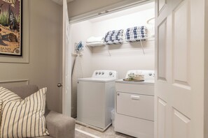 A laundry room with a washing machine, dryer, and stacked towels on a shelf. - 3 king suites + private heated pool, just steps to resort amenities. (Kissimmee)
