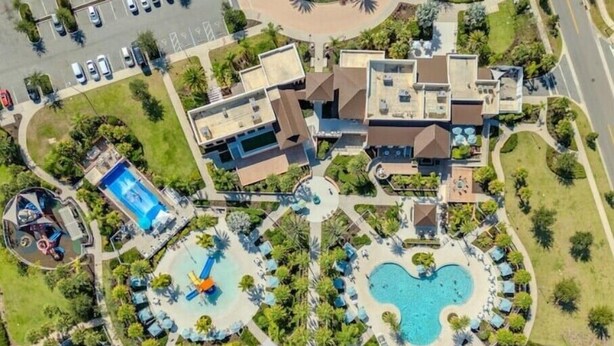 Vue aérienne d’un complexe hôtelier doté de plusieurs piscines, d’un parking et d’un aménagement paysager luxuriant.