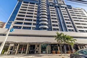 A multi-story building with a modern architectural design, featuring a prominent curved structure in the center. - Time- melhor área de lazer de Maceio (Maceió)