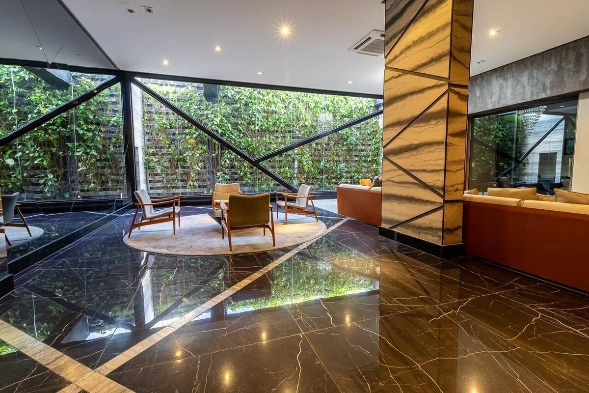 A modern lobby with a glass wall, a circular seating area, and a red sofa.