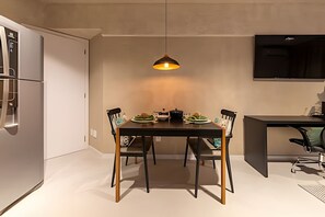 A modern kitchen with a dining table, chairs, and a pendant light. - Time- melhor área de lazer de Maceio (Maceió)