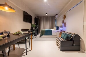 A compact living space with a dining area, a sofa, a bed, and a small kitchenette. - Time- melhor área de lazer de Maceio (Maceió)